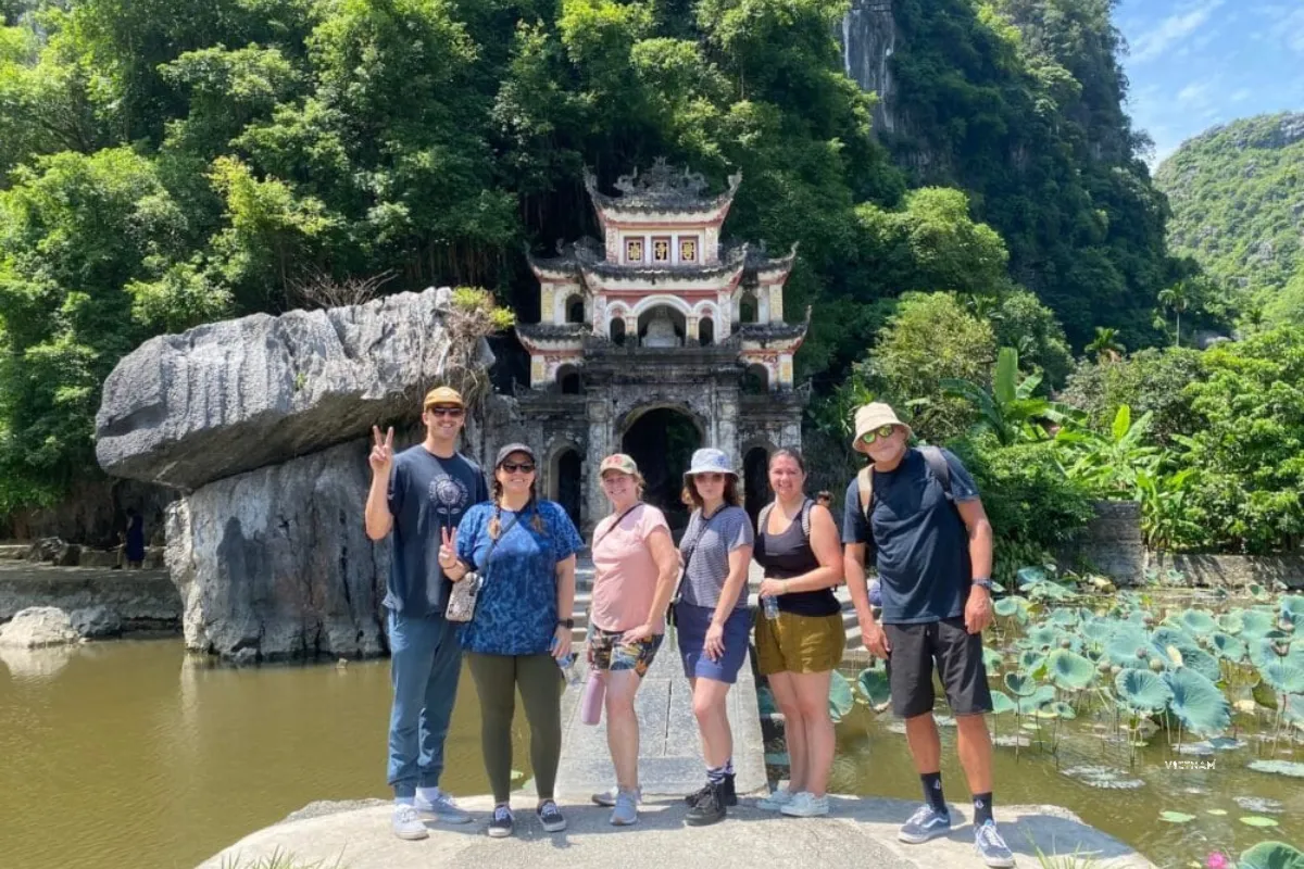 Exclusive Tam Coc Tour | Private Trip to Hoa Lu | Bich Dong & Hang Mua Bich Dong cave pagoda entrance with bridge and lotus pond